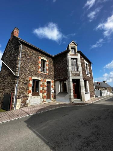 un vieux bâtiment en briques au bord d'une rue dans l'établissement La Casa Rosa, à Néant-sur-Yvel