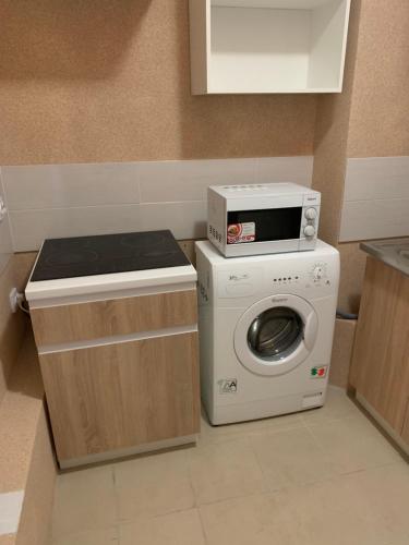 a kitchen with a washing machine and a microwave at Mega city in Kyiv