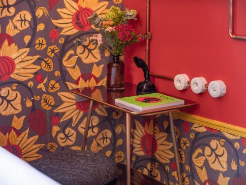 a room with a table with a vase of flowers on it at Hôtel Exquis in Paris