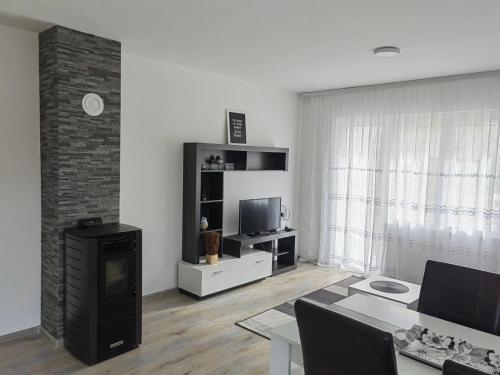 un soggiorno con un tavolo e una televisione di Apartman Planinski Raj a Žabljak
