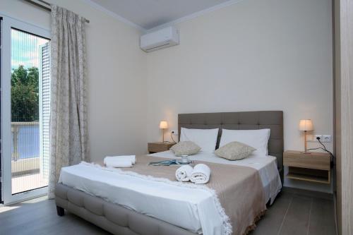 a bedroom with a large bed with towels on it at Kallithea Guesthouse in Nydri