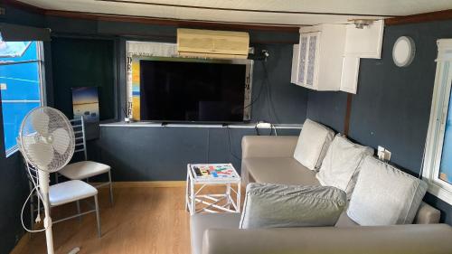 a living room with a couch and a fan at Relax in pasito blanco camping house in Maspalomas