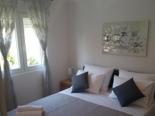a bedroom with a bed with pillows and a window at Frka-Petešić in Sali