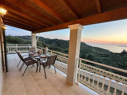 a table and chairs on a balcony with a view at Villa Long View in Avliótai