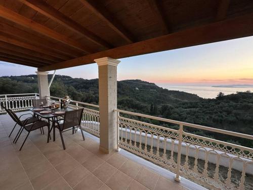 a table and chairs on a balcony with a view of the ocean at Villa Long View in Avliótai