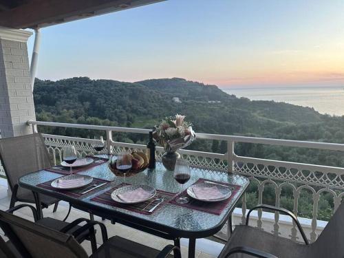 a table on a balcony with a view of the ocean at Villa Long View in Avliótai