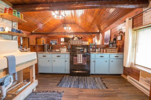 a kitchen with blue cabinets and a wooden ceiling at Blue Moon Log Cabin in Nashville