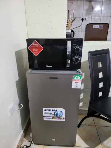 a microwave sitting on top of a refrigerator at G&G Homes Ngala Nakuru in Nakuru