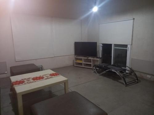 Cette chambre dispose d'une télévision et d'une table. dans l'établissement Casas del Médano, à Médano de Oro