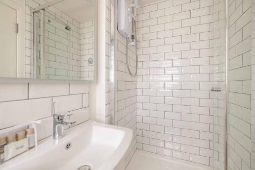 a white bathroom with a tub and a sink at Charming 3Bed 3Bath Home in Windsor with parking! in Windsor