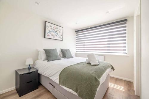 a white bedroom with a bed and a window at Charming 3Bed 3Bath Home in Windsor with parking! in Windsor