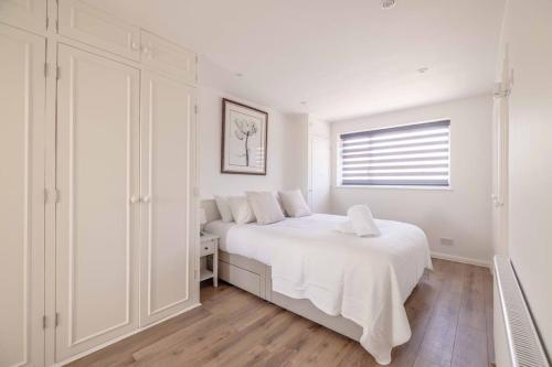 a white bedroom with a white bed and a window at Charming 3Bed 3Bath Home in Windsor with parking! - By Tempstay in Windsor