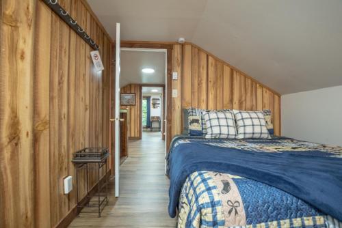 a bedroom with a bed and wooden walls at Charleys Cabin in Nashville