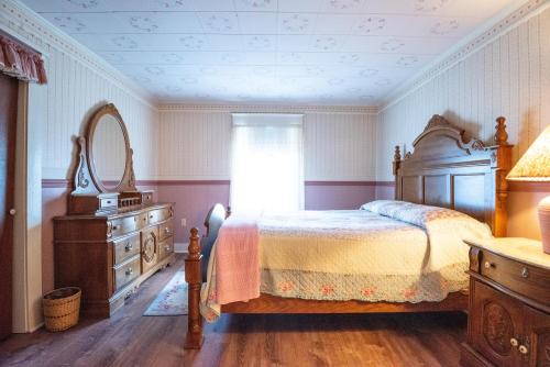 a bedroom with a bed and a dresser and a mirror at Sugar Cottage in Nashville
