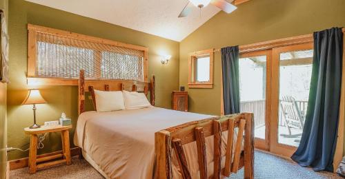 a bedroom with a bed and a window with a patio at Paradise View Log Cabin in Nashville