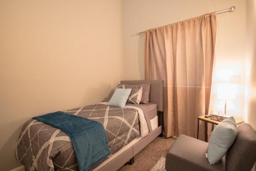 a small bedroom with a bed and a chair at Girlfriend Getaway Suite in Nashville