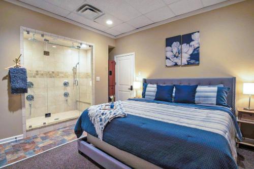 a bedroom with a blue bed and a shower at Fire And Rainfall Rooms in Nashville