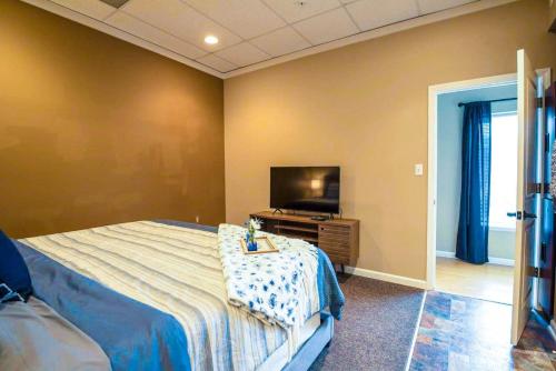 1 dormitorio con 1 cama con mesa y TV en Fire And Rainfall Rooms, en Nashville