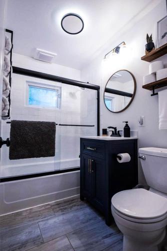 a bathroom with a toilet and a sink and a mirror at Brown County Cottage in Nashville