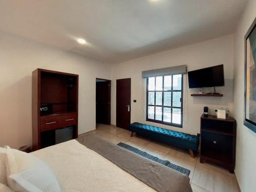 a bedroom with a bed and a tv and a window at Casa Allende Morelia in Morelia