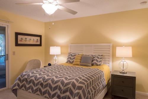 a bedroom with a bed with two lamps and a ceiling fan at 1135 Summerwind Cottage in Seabrook Island