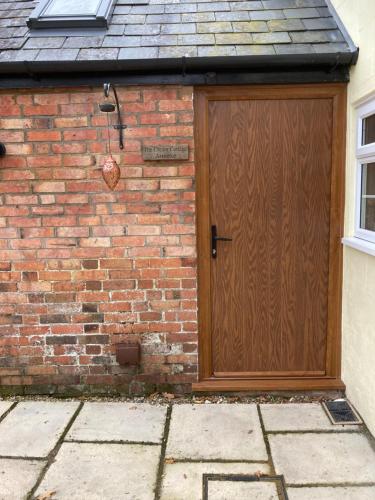 een houten deur aan de zijkant van een bakstenen gebouw bij Cream Cottage Annex in Poole