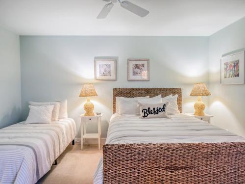 two beds in a white bedroom with two lamps at 779 Spinnaker Beach House in Seabrook Island