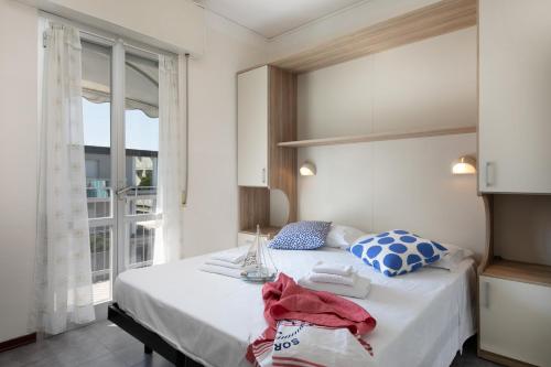 a bedroom with a large white bed with a window at B&B Villa Madana in Rimini