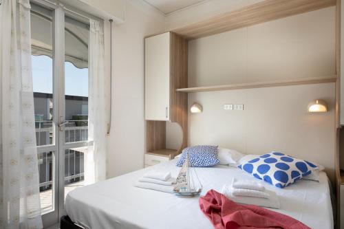 una camera da letto con un letto bianco con cuscini blu e bianchi di B&B Villa Madana a Rimini