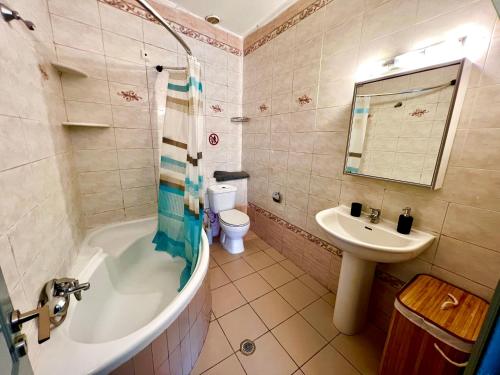 La salle de bains est pourvue d'une baignoire, d'un lavabo et de toilettes. dans l'établissement Ocean view Apartment, à Rhodes