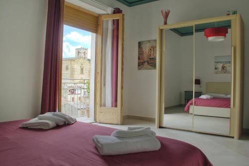 um quarto com um espelho e uma cama com toalhas em Al Borghetto em Piazza Armerina