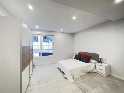 a white bedroom with a bed and a window at 4 Piso 2 habitaciones centro al lado de Príncipe 4 in Vigo