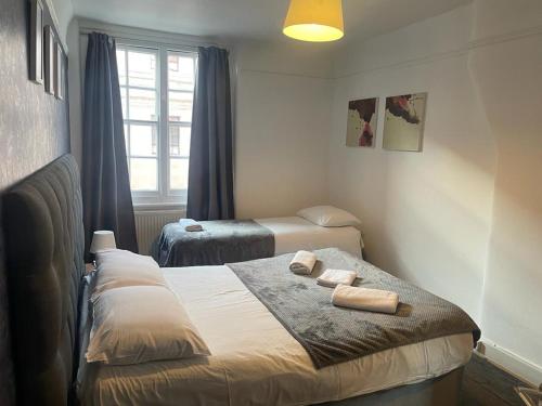 a bedroom with two beds with towels on it at Lovely Entire Flat in Kings Cross in London