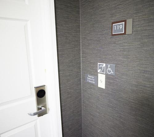 a bathroom stall with signs on a wall at Residence Inn Eugene Springfield in Eugene