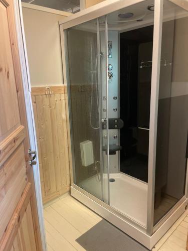 a glass shower stall in a room with at Koulumäki in Kärkölä