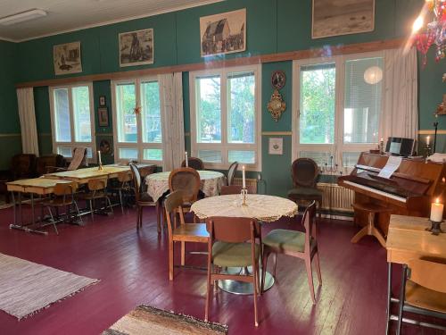 a room with tables and chairs and a piano at Koulumäen B&B in Kärkölä