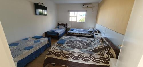 een kamer met drie bedden en een tv. bij Manantial Departamentos in Gualeguay