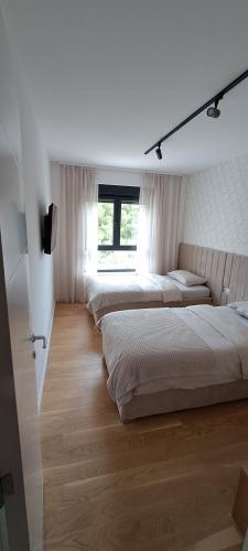 a white room with three beds and a window at Avisi Living in Trebinje