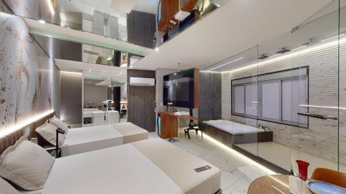 a bedroom with a white bed and a bathroom at Motel DUBAI BH in Belo Horizonte