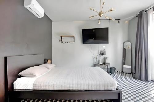 1 dormitorio con 1 cama y TV en la pared en The Studios 22800 en Ensenada