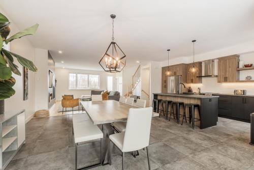 a kitchen and dining room with a table and chairs at Le Memph Chouette spacious comfortable condo cottage eco responsible 3 bedrooms private garage - hot tub & pool Memphrémagog Lake in Magog-Orford