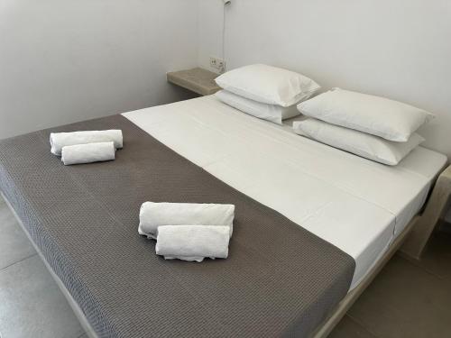 a bed with two white pillows and towels on it at Niabelo Villa in Kamari