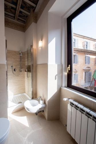 a bathroom with a toilet and a shower and a window at Campo Marzio Charming in Rome
