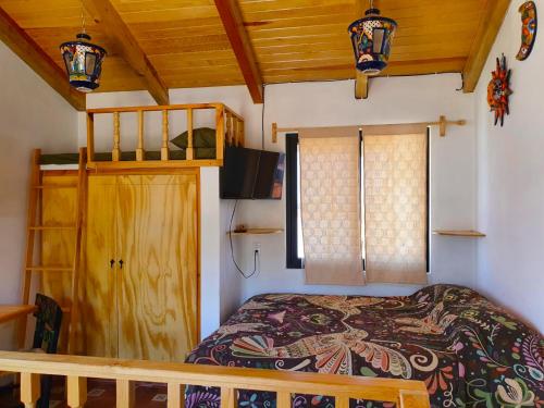 um quarto com uma cama e um tecto de madeira em Mini Casa Colibri em Mazamitla