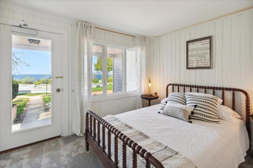 a bedroom with a bed and a large window at Lake Front home 5Min to DTPetoskey W D Fireplace King in Petoskey