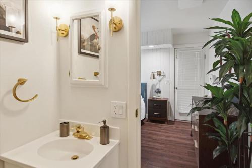 La salle de bains blanche est pourvue d'un lavabo et d'un miroir. dans l'établissement Studio 5 Min to DT Petoskey Private 4kTV King, à Petoskey