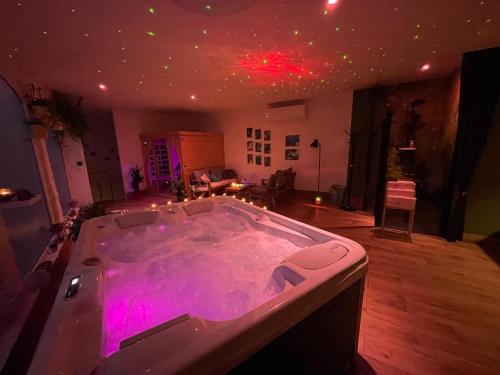 Cette chambre dispose d'une grande baignoire avec des lumières violettes. dans l'établissement wySPAne Katowice, à Katowice