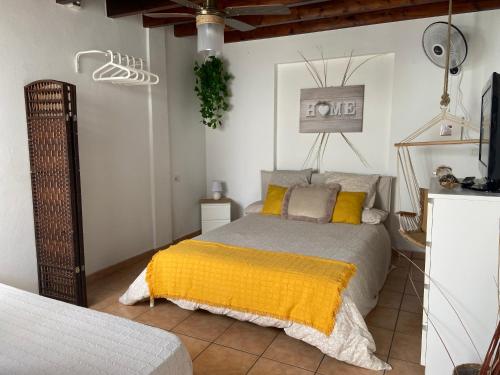 1 dormitorio con 1 cama con manta amarilla en HAPPY HOUSE NANE en Playa Honda