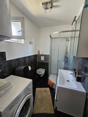 La salle de bains est pourvue d'un lave-linge et d'un lavabo. dans l'établissement Apartment half-house - 80m from sea, à Mandre