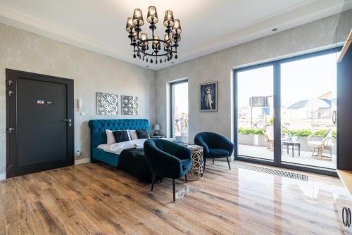 a bedroom with a blue bed and a chandelier at Apartament Glamour Vip in Ustka
